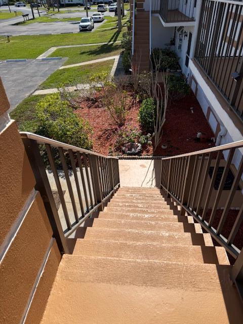 An outdoor concrete staircase with metal railings leads down to a landscaped courtyard and parking lot — 1219 S Lakes End Drive # 2, Fort Pierce FL 34982, FORT PIERCE, FL