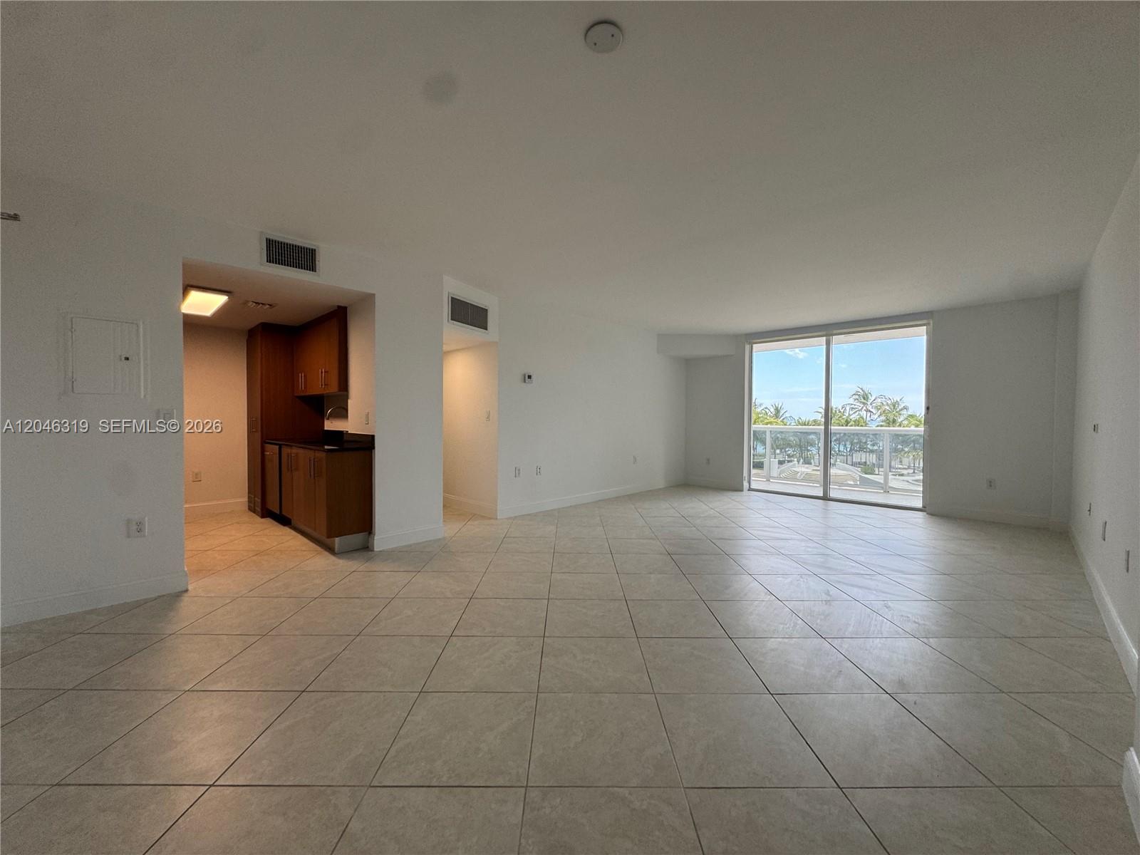 An open-concept living area features light tile flooring, a small kitchenette, and a balcony view — 10275 Collins Ave # 318, Bal Harbour FL 33154, BAL HARBOUR, FL
