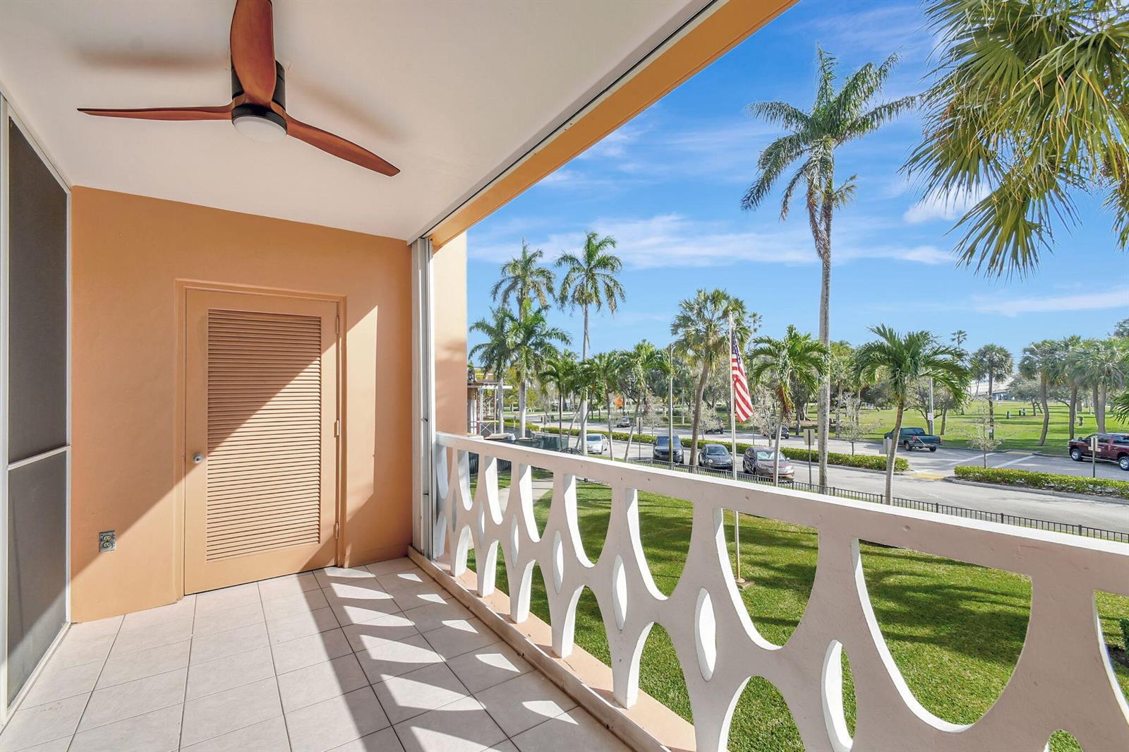 A balcony with a ceiling fan, tiled floor, and white decorative railing overlooks a park — 15 S Golfview Road # 204, FL 33460, FL