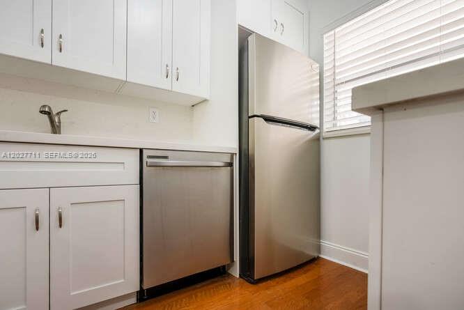 A kitchen featuring white cabinets, stainless steel appliances, and wood flooring — 4600 SW 67th Ave # 255, Miami FL 33155, MIAMI, FL