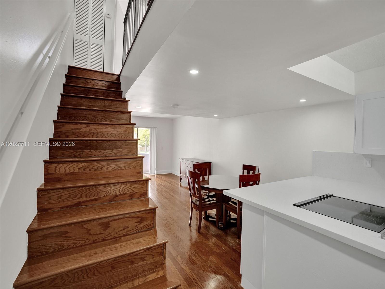A wooden staircase leads to an upper level next to a dining area and kitchen — 4600 SW 67th Ave # 255, Miami FL 33155, MIAMI, FL