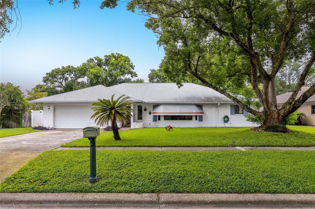 A single-story white house with a two-car garage, a palm tree, and a large tree — 521 FERNWOOD DRIVE, ALTAMONTE SPRINGS, FL