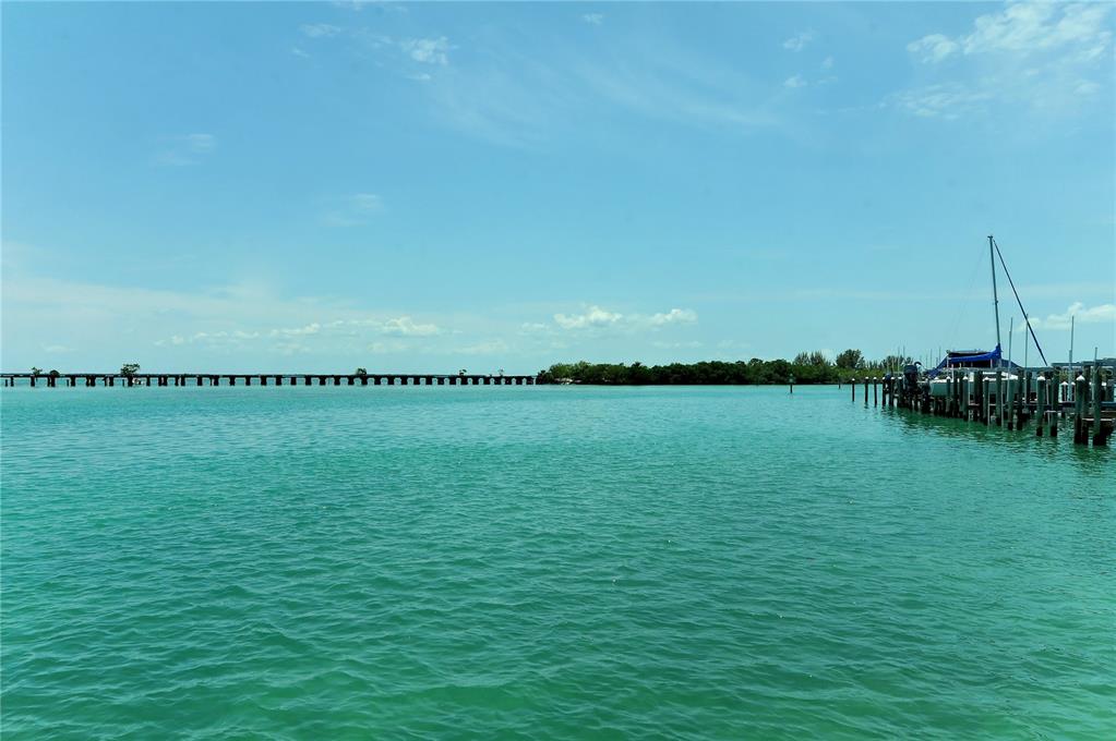 A view of a calm turquoise bay with a long pier and docked sailboats — 6040 BOCA GRANDE CAUSEWAY UNIT 5, BOCA GRANDE, FL