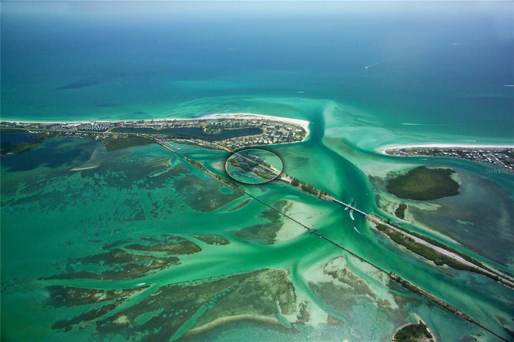 An aerial view shows a coastal bridge connecting islands surrounded by shallow turquoise water — 6040 BOCA GRANDE CAUSEWAY UNIT 5, BOCA GRANDE, FL