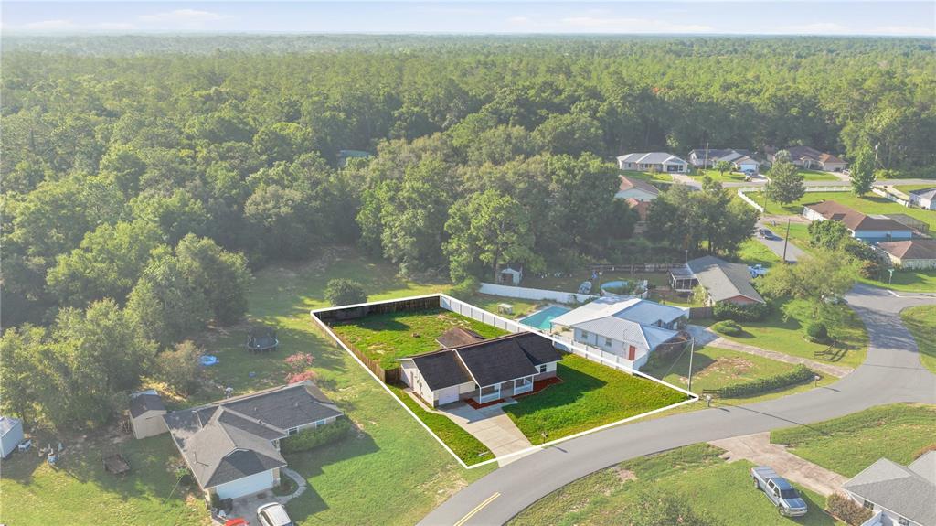 An aerial view shows a single-story house with a fenced backyard on a suburban street — 3 ALMOND TRAIL PLACE, OCALA, FL
