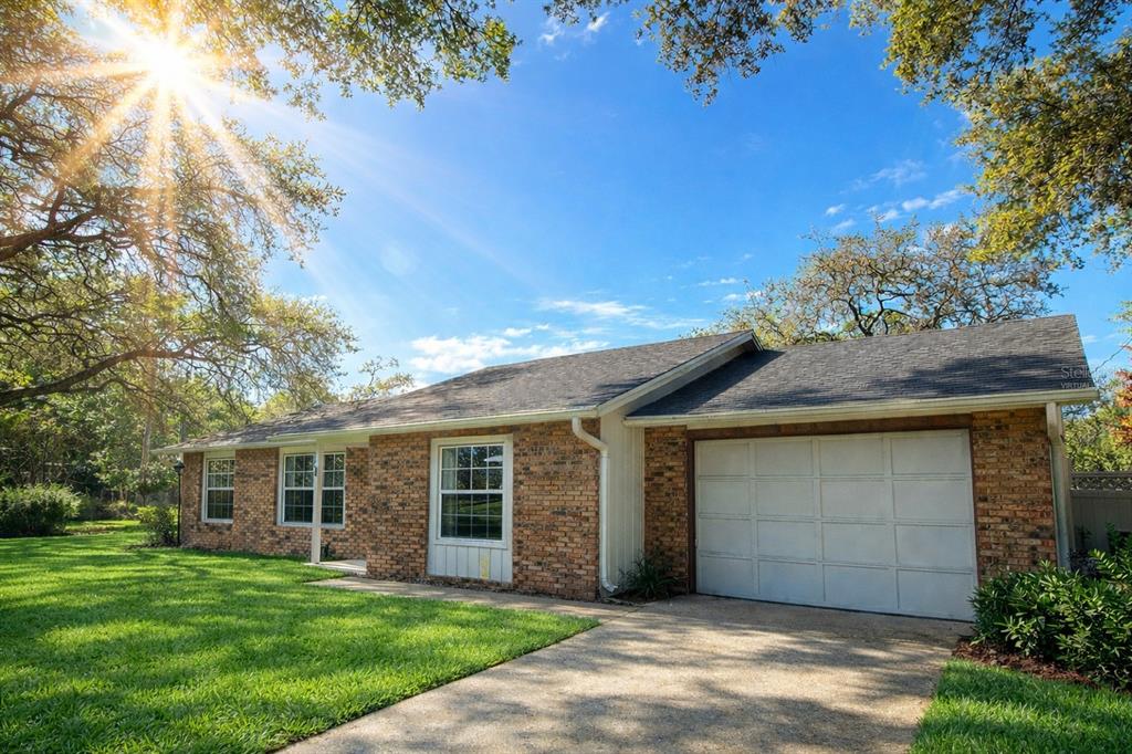A single-story brick house with a white garage door and a large front lawn — 700 SWARTHMORE ROAD, DELAND, FL