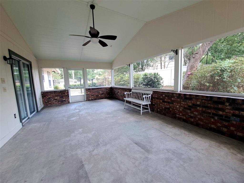 A screened-in porch features a concrete floor, brick walls, a ceiling fan, and a bench — 700 SWARTHMORE ROAD, DELAND, FL