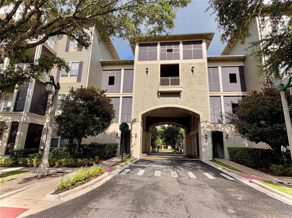 A multi-story apartment building exterior features balconies, shuttered windows, and a ground-level entrance with stairs — 650 CAMPUS STREET UNIT 204, CELEBRATION, FL