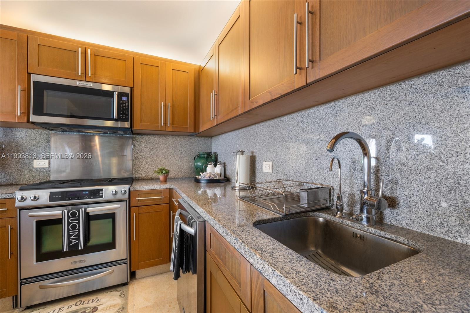 A kitchen features wood cabinets, granite countertops, stainless steel appliances, and a stainless steel sink — 8101 Paseo Sotogrande # 8101, VA 23000, VA