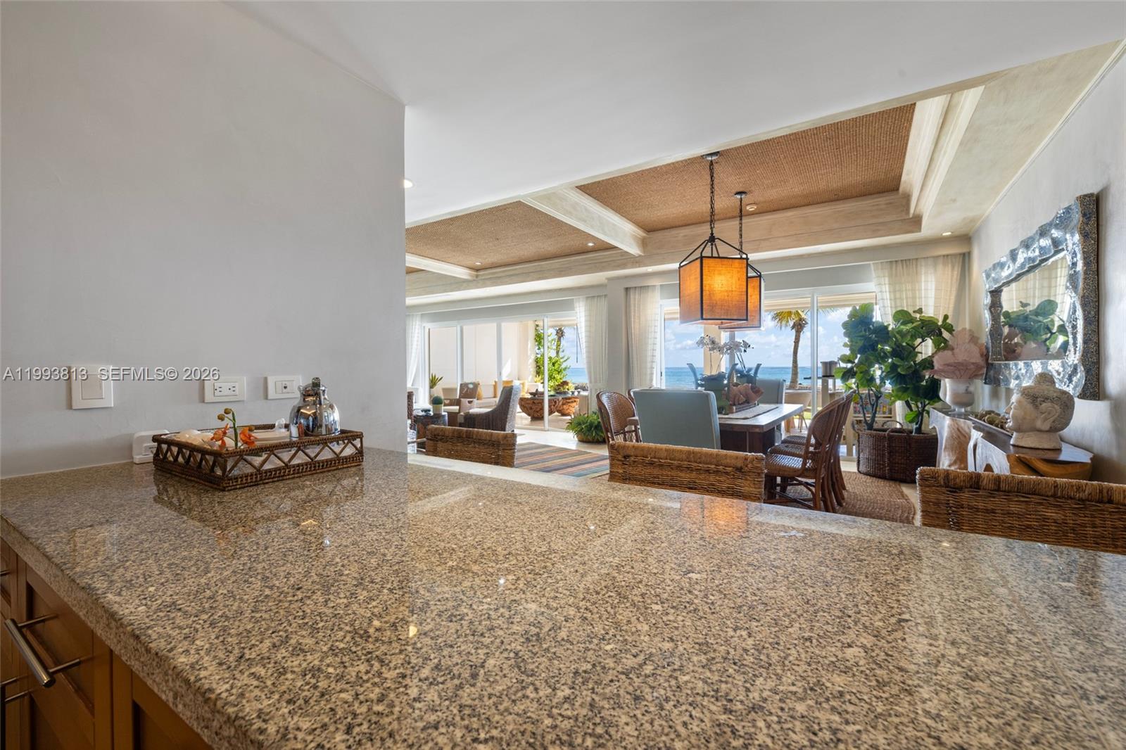 A granite countertop overlooks a dining area and living room with ocean views — 8101 Paseo Sotogrande # 8101, VA 23000, VA