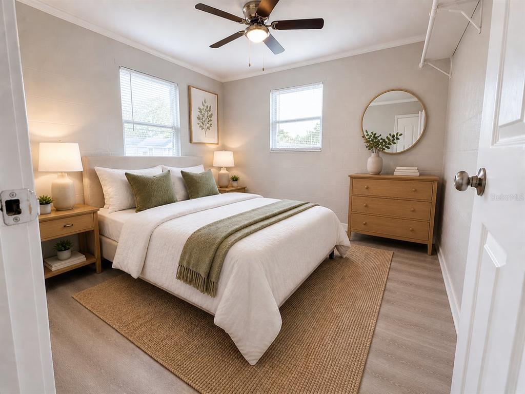 A bedroom features a queen bed, two nightstands, a dresser, and a round wall mirror — 2305 SW 2ND STREET UNIT A, OCALA, FL