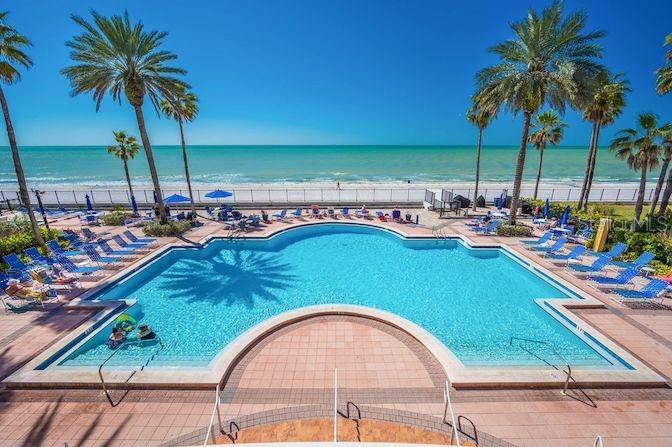 An outdoor swimming pool sits on a patio overlooking a sandy beach and the ocean — 16550 GULF BOULEVARD UNIT 545, NORTH REDINGTON BEACH, FL