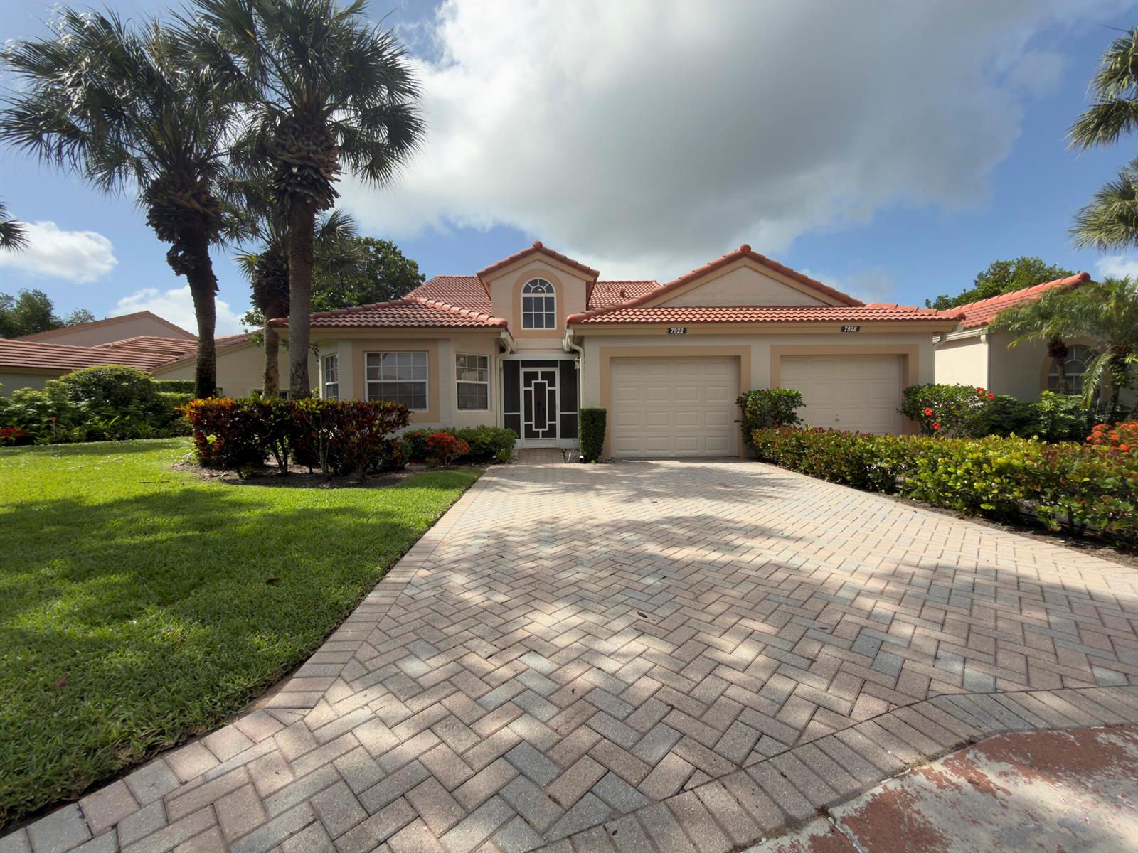 A single-story house with a tiled roof, two garage doors, and a paved driveway — 7922 Sandy Pointe Drive, Delray Beach FL 33446, DELRAY BEACH, FL