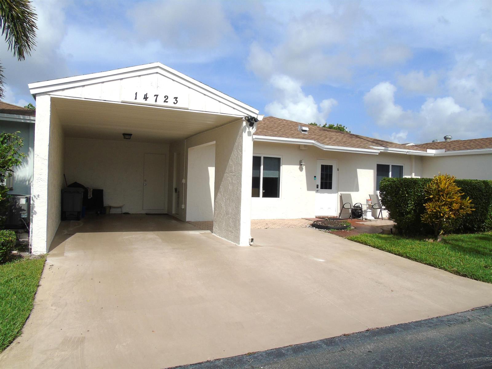 A single-story house with a carport, a concrete driveway, and a small front patio area — 14723 Wildflower Lane, Delray Beach FL 33446, DELRAY BEACH, FL