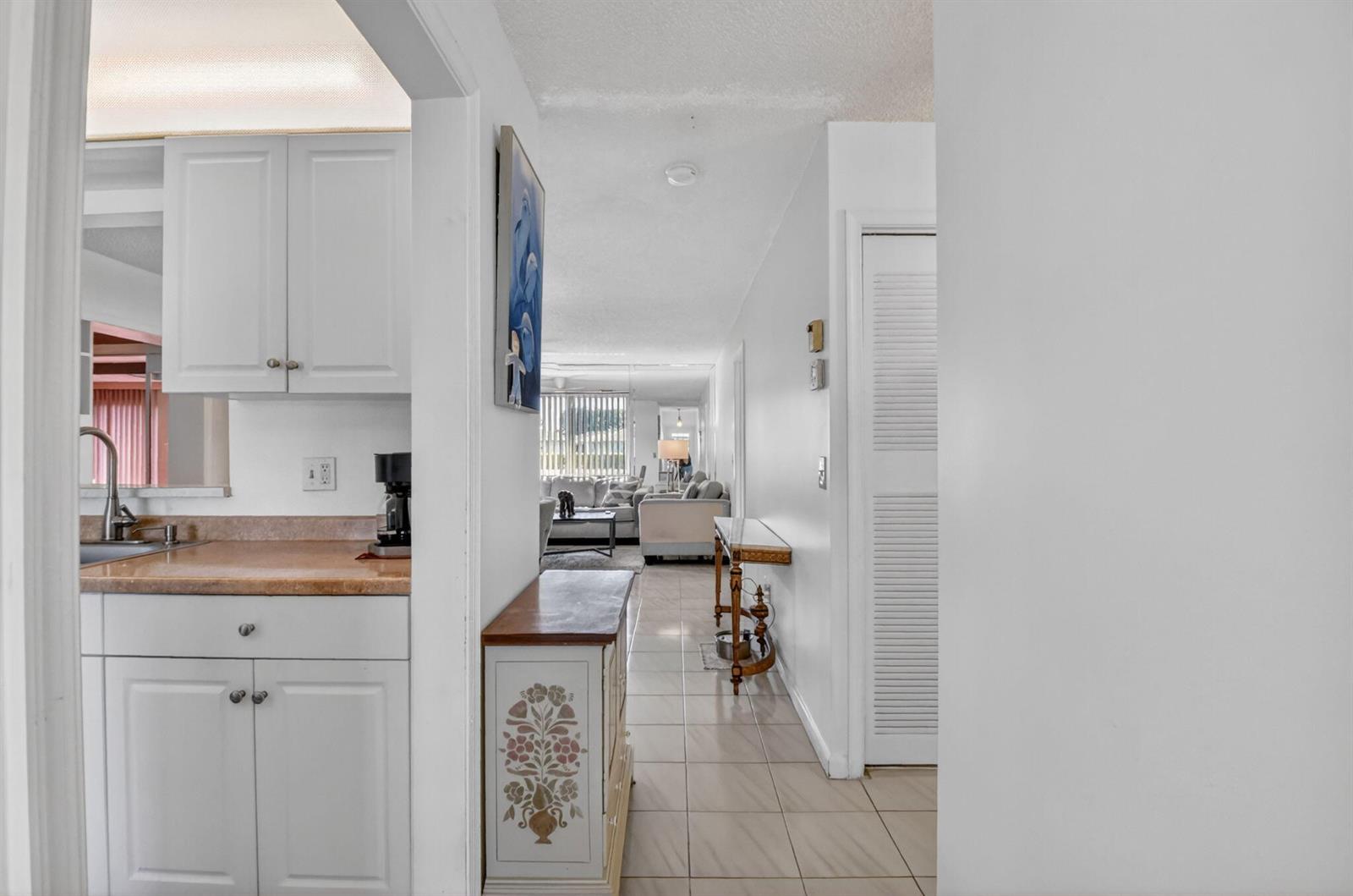 A view from a hallway looking into a kitchen and a living room beyond — 14723 Wildflower Lane, Delray Beach FL 33446, DELRAY BEACH, FL