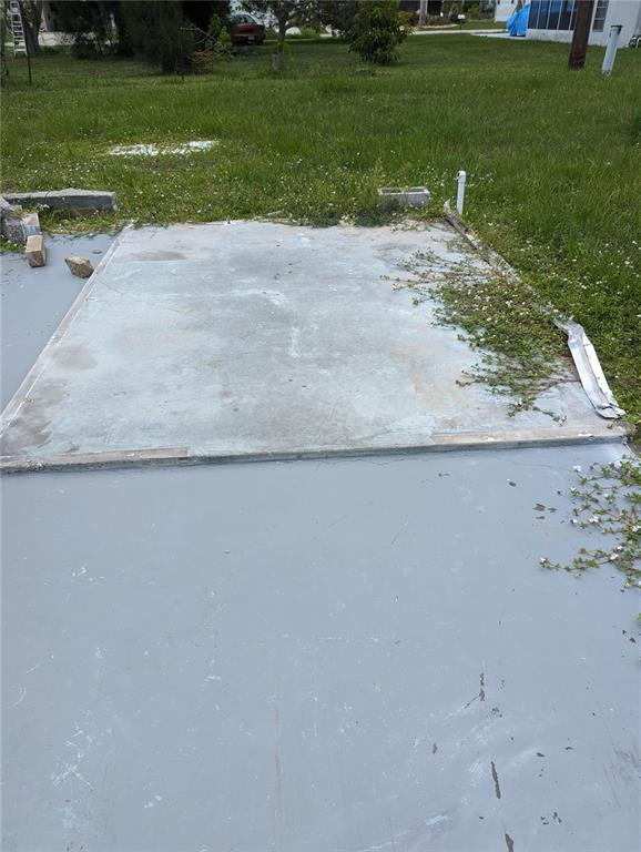 A concrete slab foundation sits in a grassy yard next to a painted patio area — 1295 SEAGULL DRIVE, ENGLEWOOD, FL