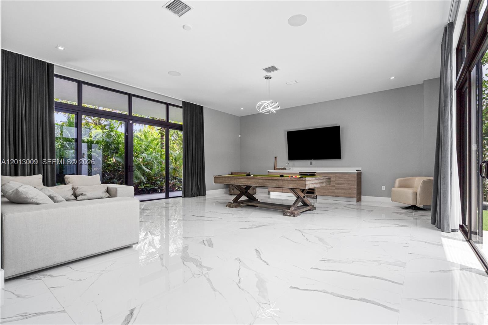 A spacious game room features a pool table, a wall-mounted television, and large glass doors — 16529 N Botaniko Dr, Weston FL 33326, WESTON, FL
