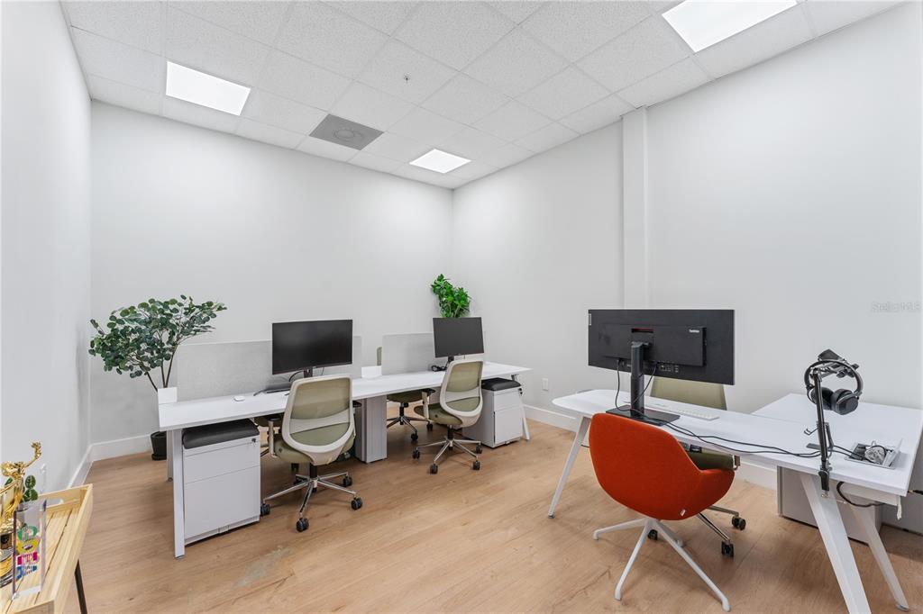 A modern office space features three desks, ergonomic chairs, and light wood flooring — 7726 WINEGARD ROAD, ORLANDO, FL