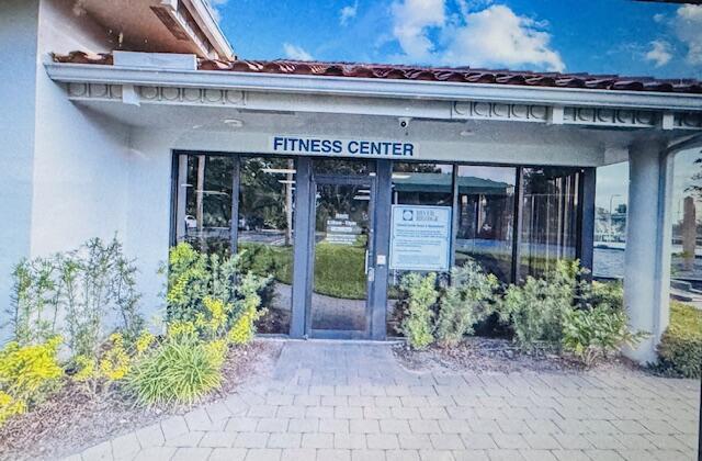 The exterior entrance of a fitness center features a glass door and a paved walkway — 503 Landings Boulevard, FL 33413, FL
