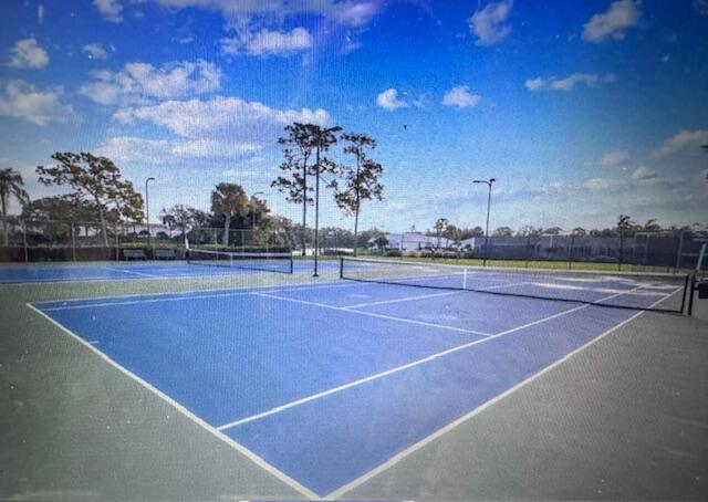A blue outdoor pickleball court with a net and surrounding chain-link fencing — 503 Landings Boulevard, FL 33413, FL