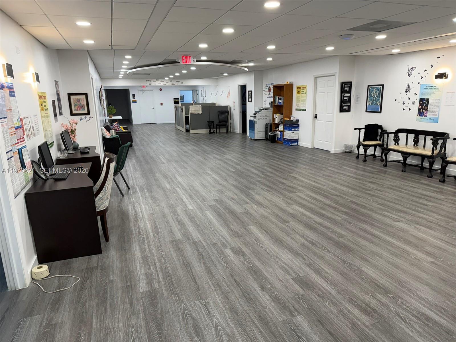 A spacious office interior features gray wood-look flooring, recessed lighting, and a cubicle area — 2650 SW 27th Ave, Miami FL 33133, MIAMI, FL