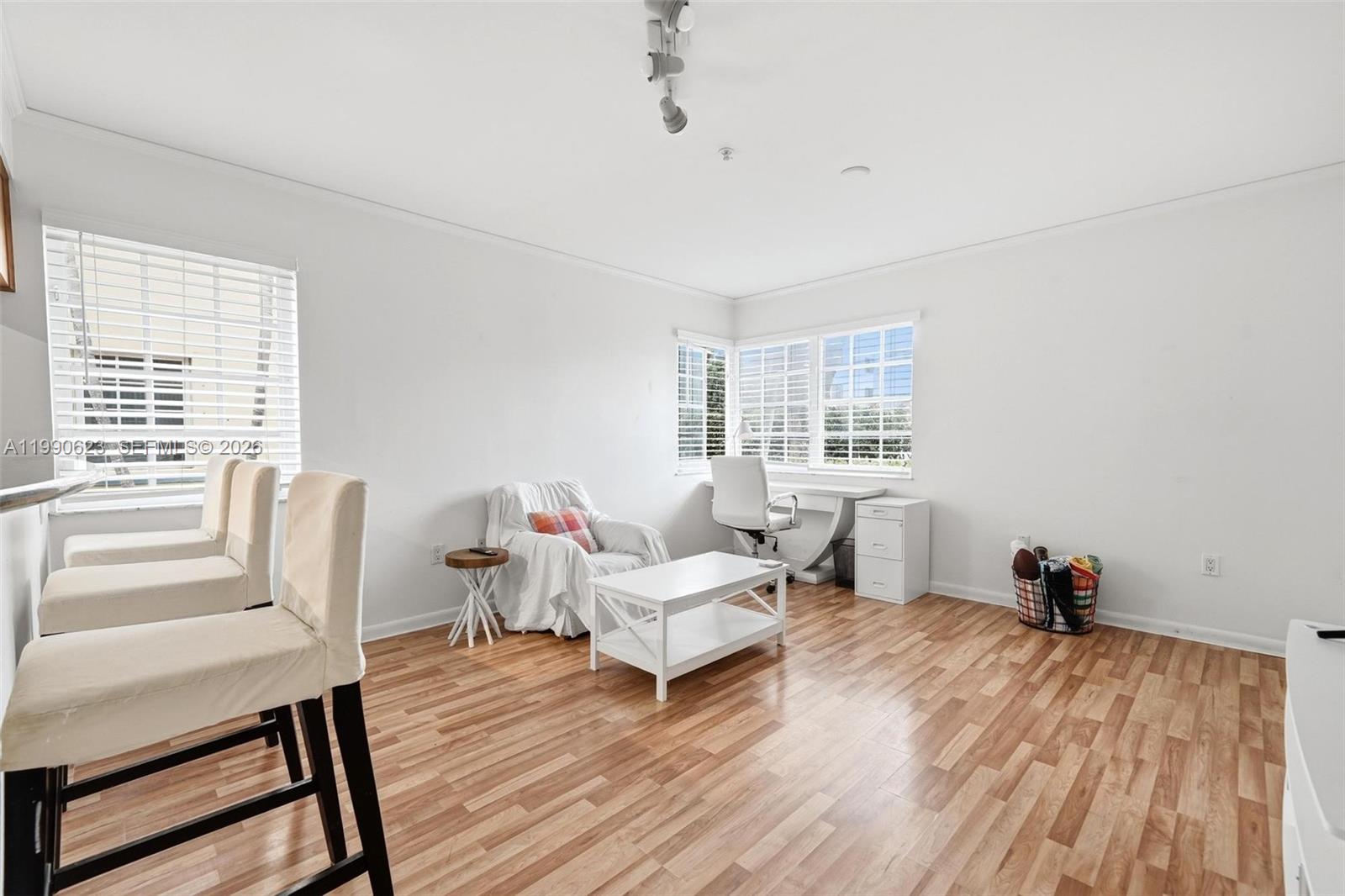 A living area with light wood floors, a white coffee table, and a desk area — 600 Euclid Ave # A2, Miami Beach FL 33139, MIAMI BEACH, FL
