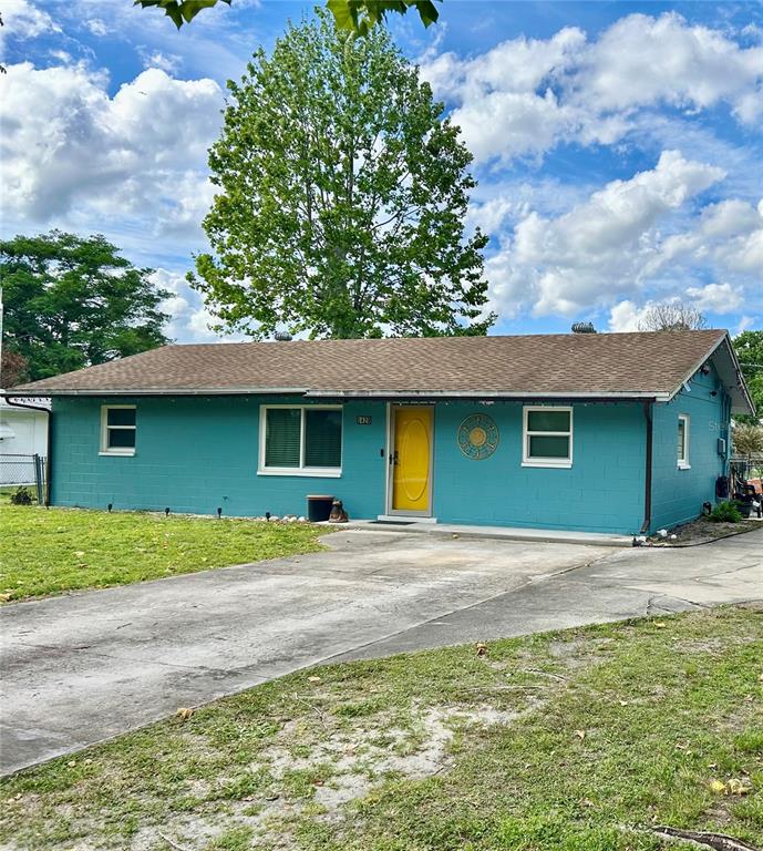 A single-story teal house with a yellow front door and a concrete driveway — 1420 BELLEVIEW ROAD, COCOA, FL
