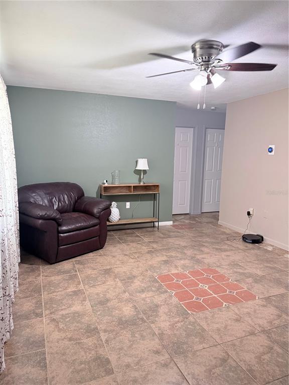 A living room features a dark leather armchair, a console table, and tile flooring — 1420 BELLEVIEW ROAD, COCOA, FL