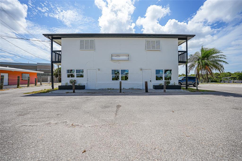A two-story white building with two front doors and a paved parking lot — 1261 BEACH ROAD, ENGLEWOOD, FL