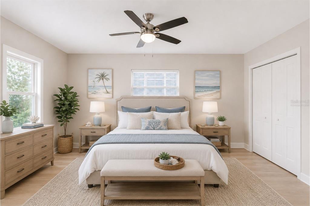 A bedroom features a bed with blue accents, two nightstands, a dresser, and a ceiling fan — 1261 BEACH ROAD, ENGLEWOOD, FL