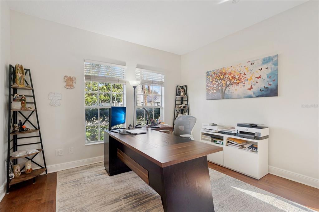 A home office features a dark wood desk, a white storage unit, and two corner shelves — 9310 MUSTARD LEAF DRIVE, ORLANDO, FL