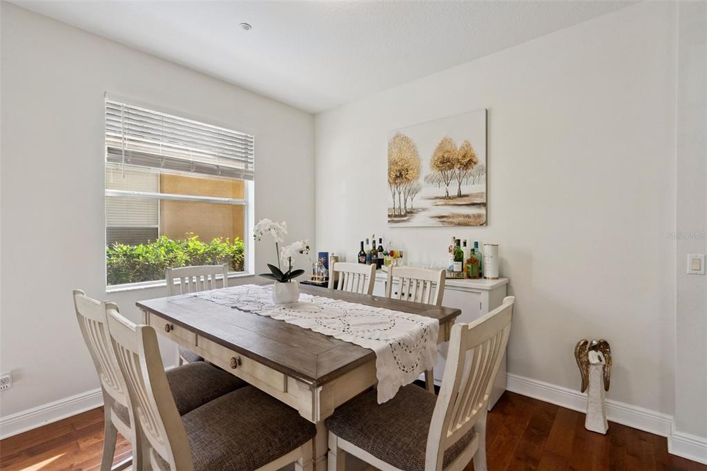 A dining room features a wooden table with chairs, a white sideboard, and a window — 9310 MUSTARD LEAF DRIVE, ORLANDO, FL