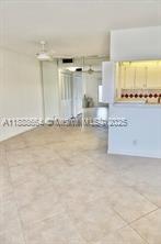 An interior view shows a tiled living area leading toward a kitchen with a pass-through window — 198 E Mansfield  E # 198, Boca Raton FL 33434, BOCA RATON, FL