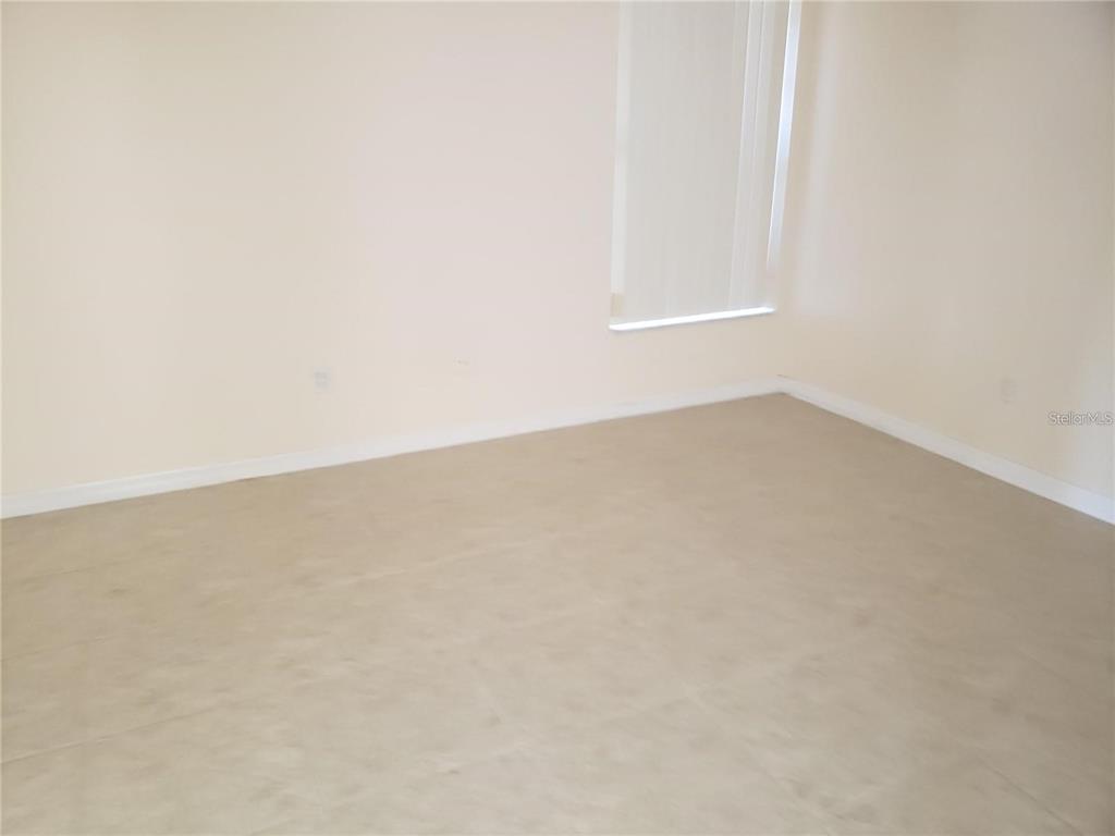 An empty room with light-colored walls, tile flooring, and a window with vertical blinds — 3792 DUNWICH AVENUE, ORLANDO, FL
