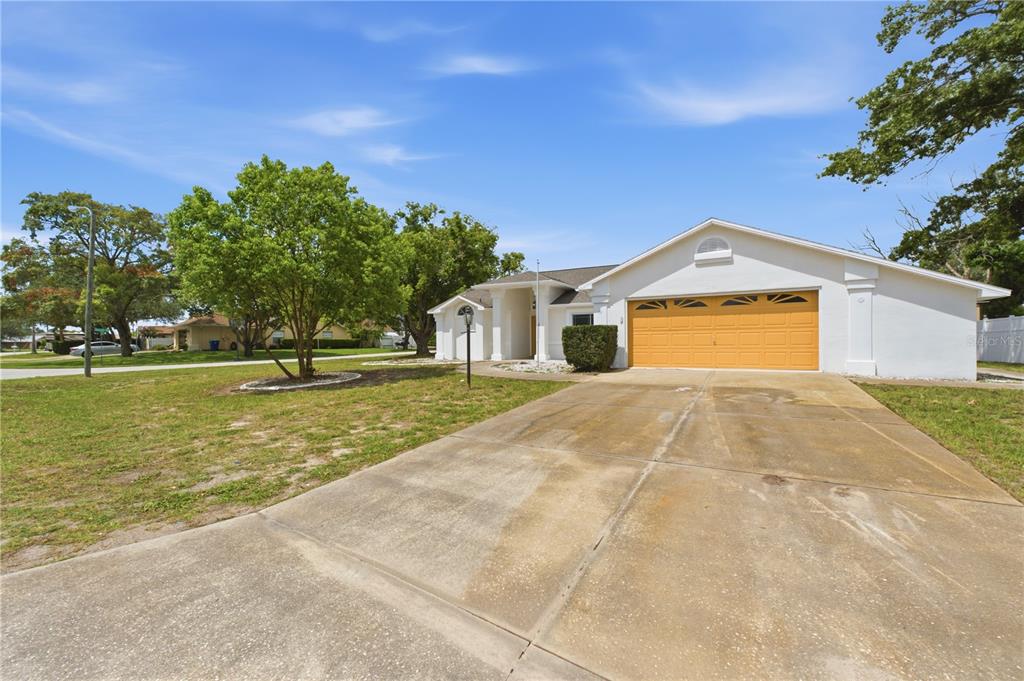 A single-story house with a white exterior, a two-car garage, and a concrete driveway — 5098 WINTERVILLE ROAD, SPRING HILL, FL