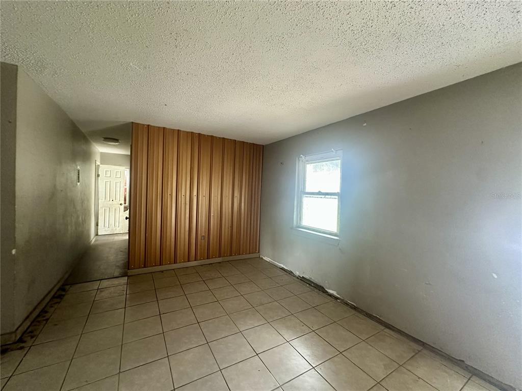 An interior room features tile flooring, a corrugated metal accent wall, and a single window — 4640 NE CUBITIS AVENUE, ARCADIA, FL