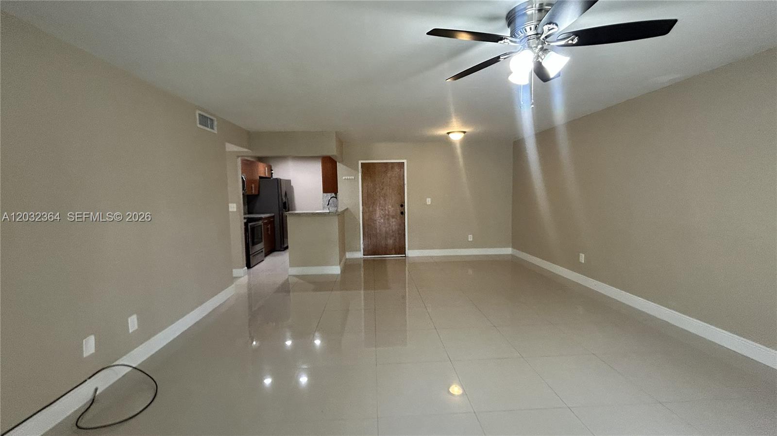 An open-concept living area features light-colored tile flooring, beige walls, and a ceiling fan — 10377 N Kendall Dr # K8, Miami FL 33176, MIAMI, FL