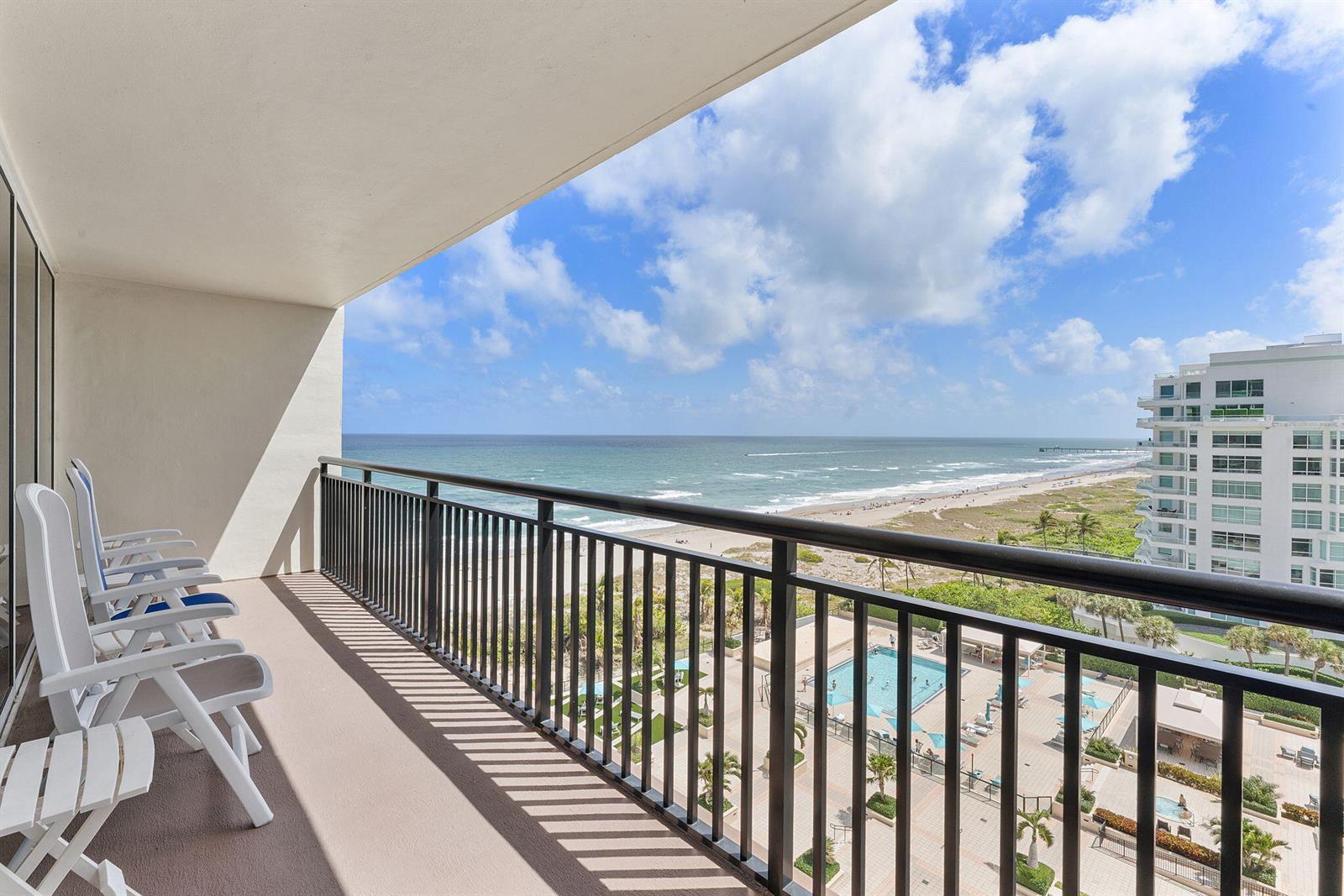 A balcony with white chairs overlooks a swimming pool, sandy beach, and the ocean — 2000 S Ocean Boulevard # 10h, Boca Raton FL 33432, BOCA RATON, FL