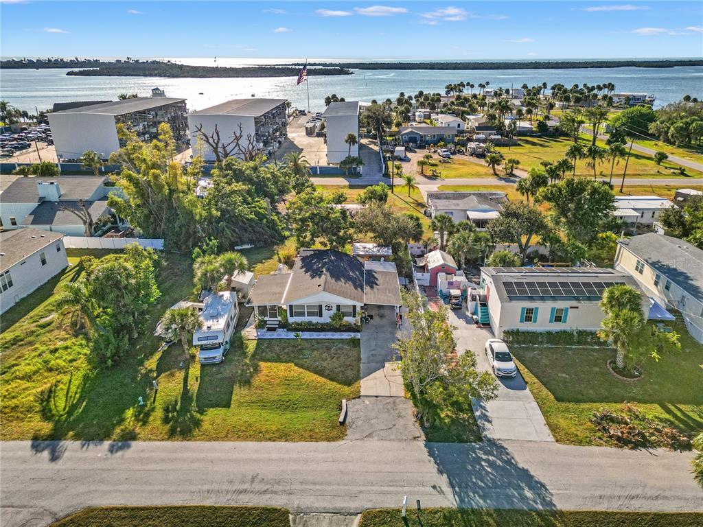 An aerial view shows a residential property with a house, driveway, and nearby waterfront — 3130 BOURBON STREET, ENGLEWOOD, FL