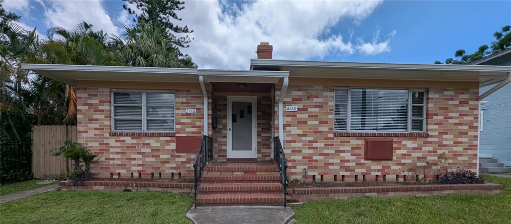 A single-story brick duplex with two front doors, a central staircase, and a flat roof — 206 12TH AVENUE N, ST PETERSBURG, FL