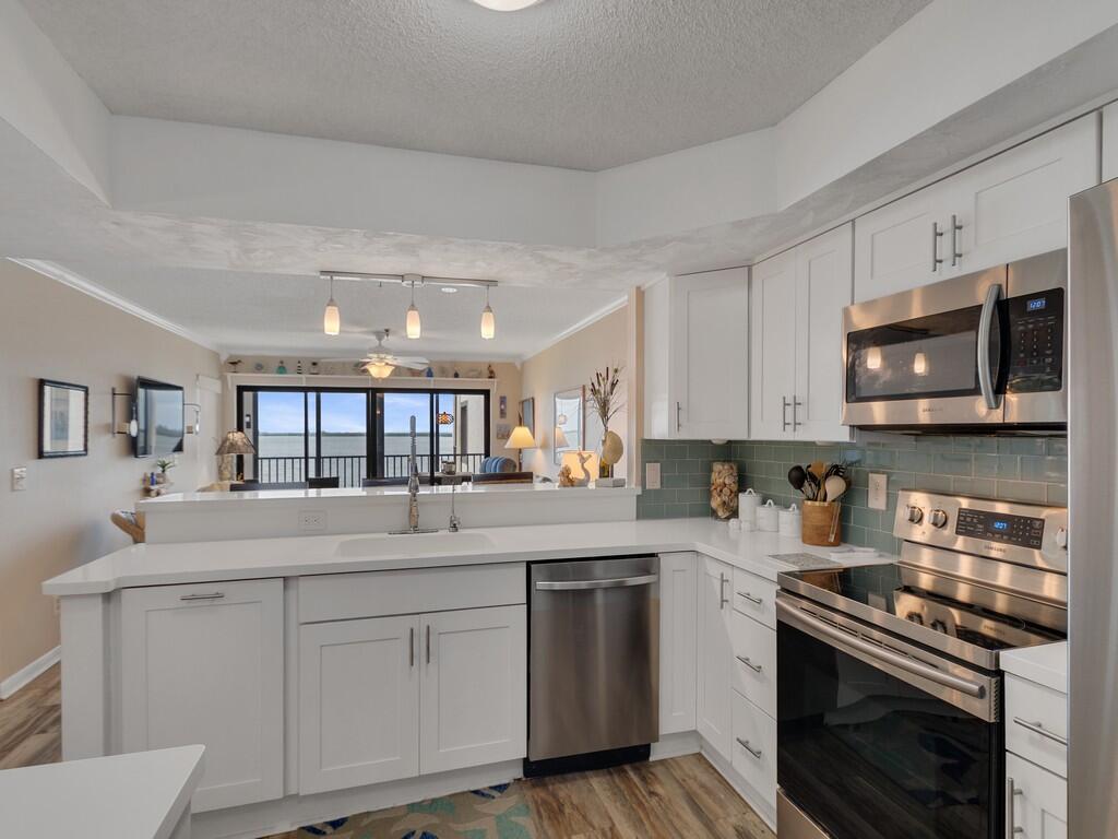 A kitchen with white cabinets, stainless steel appliances, and a view of the ocean — 9612 Riverside Drive # 203, Sebastian FL 32958, SEBASTIAN, FL