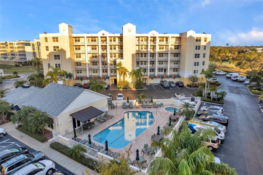 An aerial view shows a multi-story apartment building with an outdoor pool and parking lot — 1200 COUNTRY CLUB DRIVE UNIT 3105, LARGO, FL