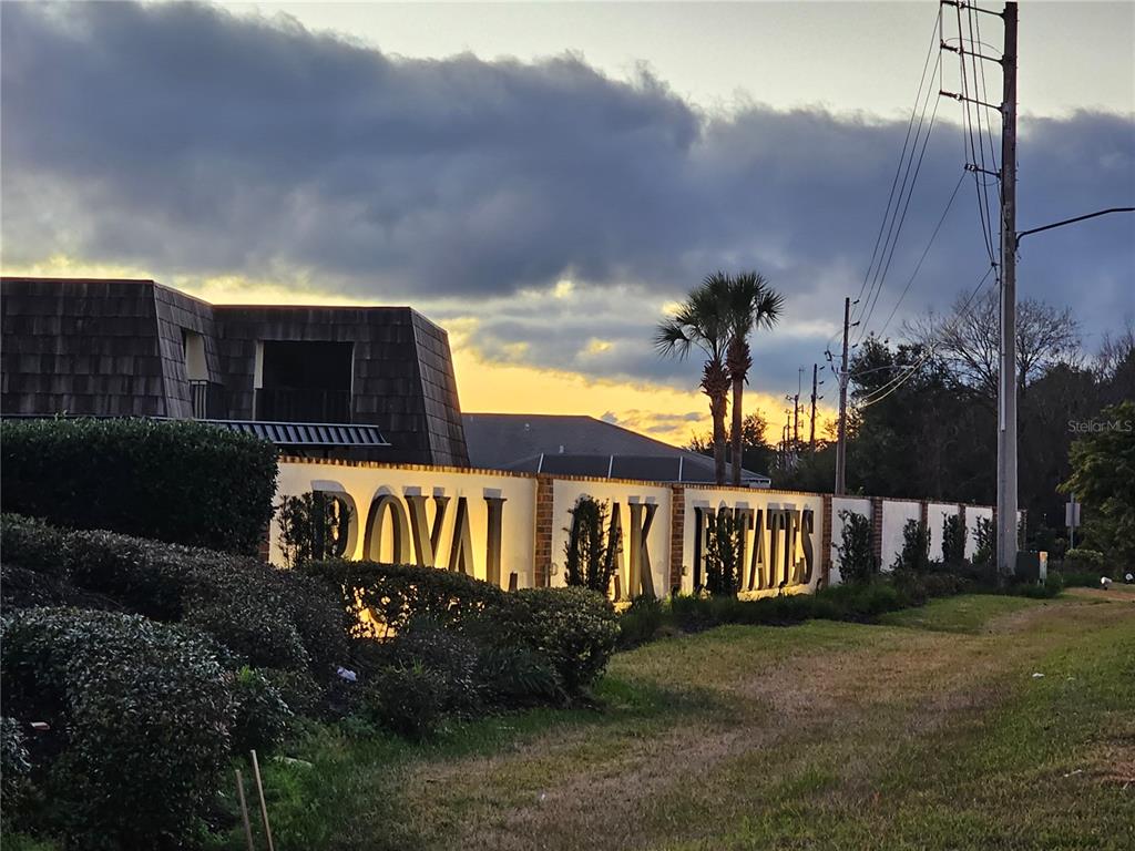 A sign for Royal Oak Estates stands in front of a building at sunset — 2927 TANGERINE COURT, LEESBURG, FL