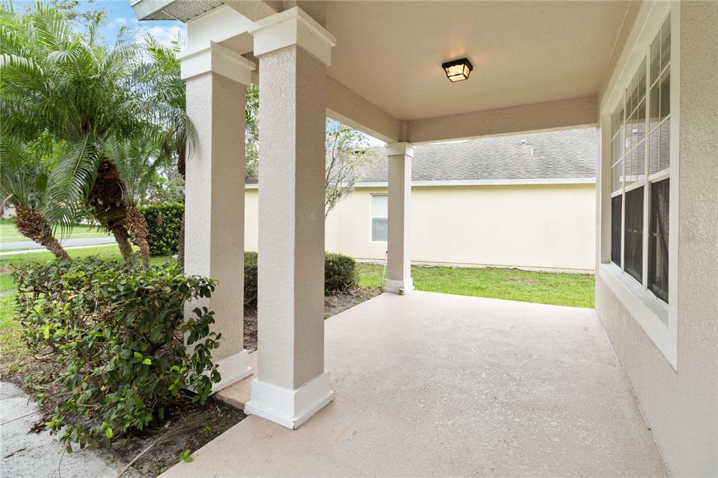 A covered concrete porch features two square columns and a ceiling-mounted light fixture — 2173 GRANGER AVENUE, KISSIMMEE, FL