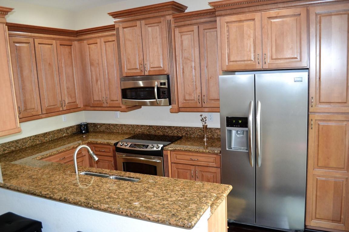 A kitchen features wood cabinets, granite countertops, and stainless steel appliances — 8305 NW 7th Court, Boca Raton FL 33487, BOCA RATON, FL