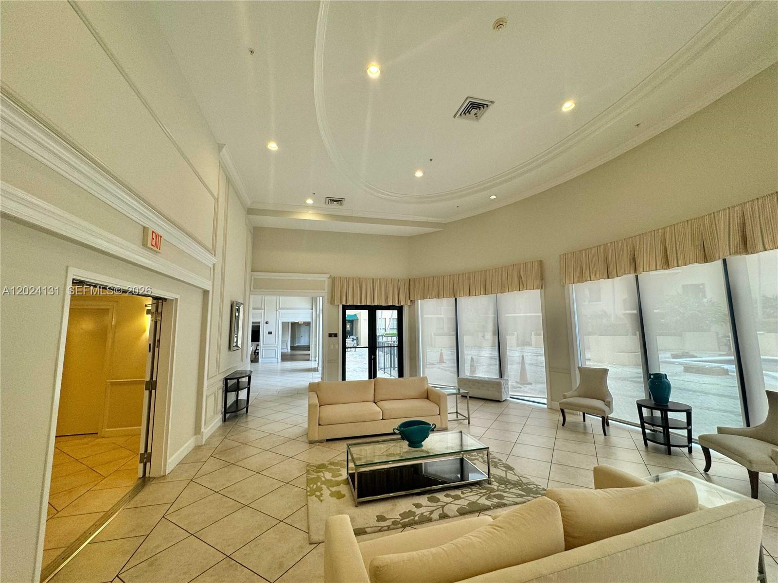 A spacious lobby features tile floors, neutral furniture, and large windows with beige valances — 55 Merrick Way # 831, Coral Gables FL 33134, CORAL GABLES, FL