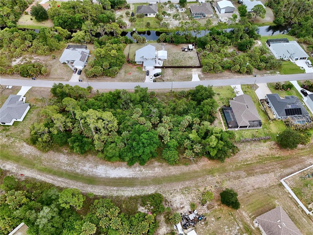 An aerial view shows a wooded vacant lot situated between several residential houses — KISKA ROAD, NORTH PORT, FL