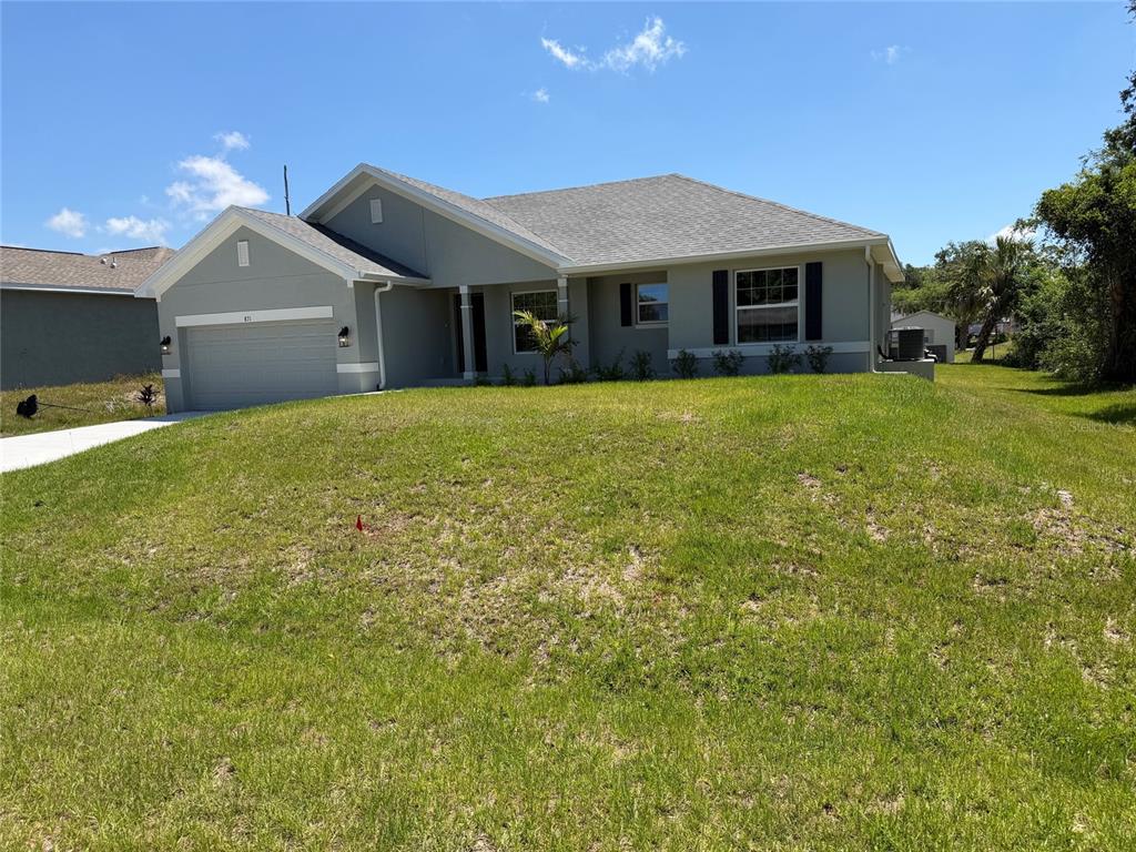A single-story house with a gray exterior, a two-car garage, and a large front lawn — 871 RED BAY STREET, PORT CHARLOTTE, FL