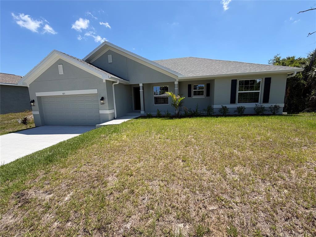 A single-story house with a gray stucco exterior, a two-car garage, and a front lawn — 871 RED BAY STREET, PORT CHARLOTTE, FL