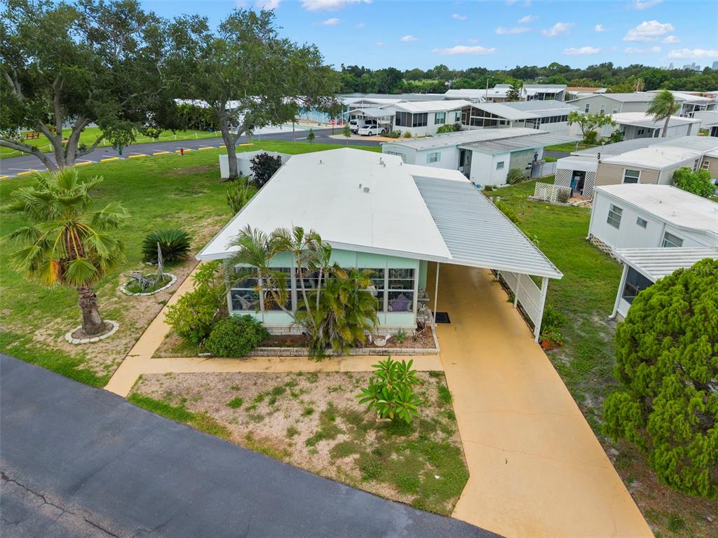 An aerial view of a light-colored mobile home with a carport and surrounding landscaping — 684 MOUNT LANCASTER AVENUE NE UNIT 644, ST PETERSBURG, FL